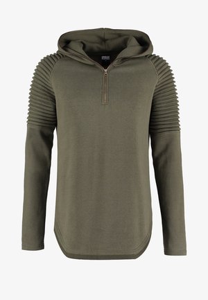 Olivno zelena kapuca z zadrgo spredaj, ki ima rebraste detajle na ramenih, dolge rokave in zaobljen rob. Mehka tekstura tkanine.
