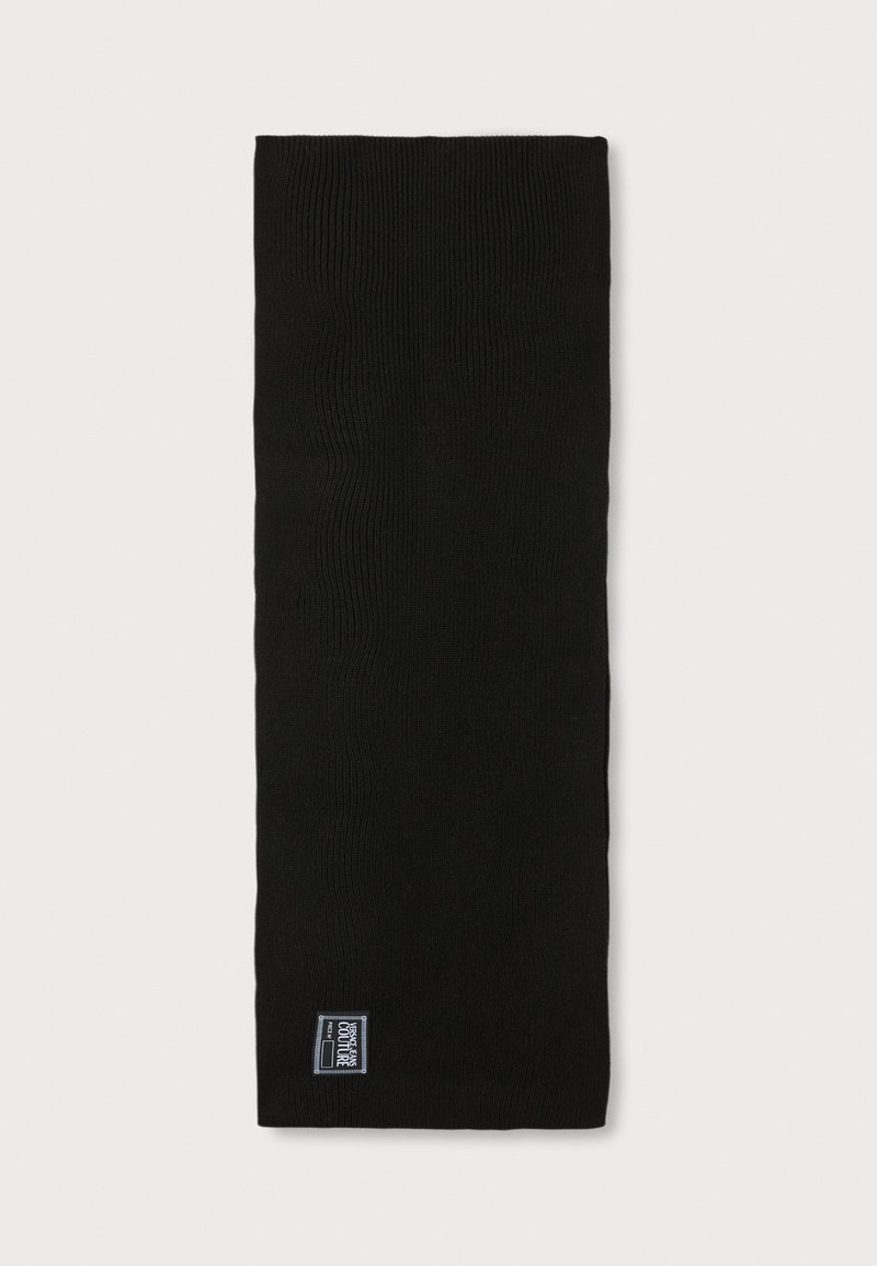 Μαύρο πλεκτό κασκόλ σε ορθογώνιο σχήμα, με ραβδωτή υφή και μια μικρή, επώνυμη ετικέτα σε ένα άκρο.