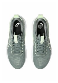 Helle grüne Sportschuhe mit einer strukturierten Oberseite, Schnürdesign und weißen Sohlen. Mit silbernen Akzenten und einer aerodynamischen Form.