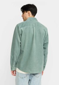 Groene corduroy blouse met een klassieke kraag, lange mouwen en knoopmanchetten, met een gestructureerd ribbelpatroon en een rechte zoom.