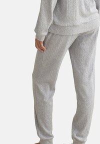 Grijs gebreid loungewear-set met verticale textuurpatronen, met rib gebreide manchetten en een tailleband. Zacht, lichtgewicht materiaal, casual pasvorm.