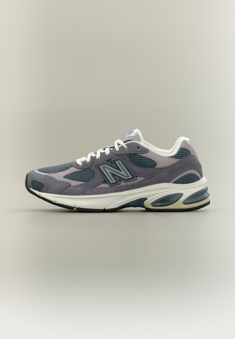 Chaussure de course New Balance gris et bleu avec des lacets blancs et une semelle épaisse blanche, vue de côté extérieur sur un fond neutre.