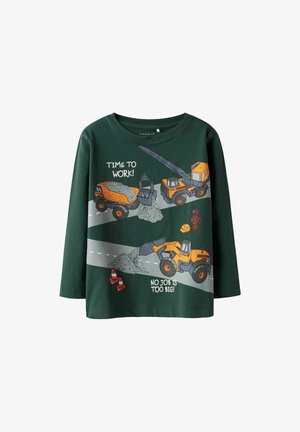 T-shirt à manches longues vert avec des graphiques de véhicules de construction en orange et gris. Le texte indique "IL EST TEMPS DE TRAVAILLER !" et "AUCUN TRAVAIL N'EST TROP GRAND !"