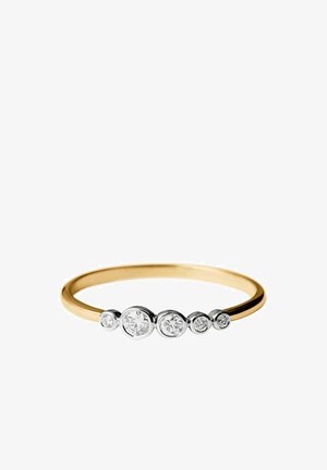 Anillo delgado de oro con cinco diamantes redondos de diferentes tamaños engastados en biseles, dispuestos en línea sobre la banda.