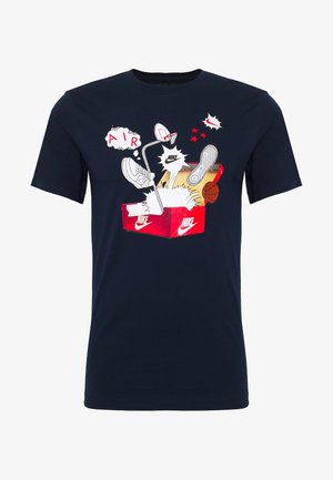 Tummansininen paita, jossa on graafinen kuva punaisesta Nike-kengäboxista, tennarit, koripallo ja koripallokori sekä "AIR" ja Nike-logot sarjakuvamaisissa puhkusyissä.