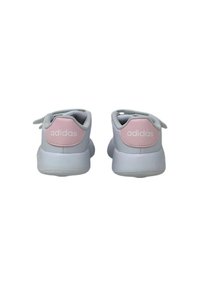 White athletic shoes with a light pink accent on the heel. Features a smooth leather-like material and a rounded shape. Adidas logo on the back.
