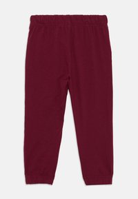 Pantaloni sportivi in cotone bordeaux con vita e polsini elasticizzati, caratterizzati da una texture liscia e un design a gamba dritta.