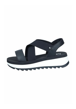 Sandales à plateforme noires avec un design à brides croisées, en matière synthétique imitant le cuir, straps texturés, semelle épaisse blanche et motif en zigzag pour l'adhérence.