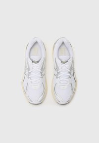 Weiße Sportschuhe mit einem Obermaterial aus Mesh, silbernen Akzenten und einer strukturierten Gummisohle. Schnürsenkel, gepolsterter Kragen und Logodetail auf der Zunge.