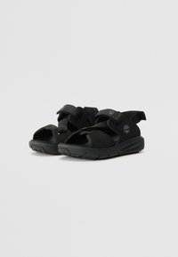 Sorte sandaler med åbne tæer og justerbare velcroremme. Blødt tekstilmateriale på overdelen og struktureret gummisål for godt greb. Holdbart design.