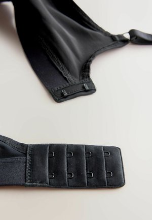 Black bra featuring smooth fabric, adjustable straps, and a four-hook closure on the back. Subtle stitching accents along the edges.