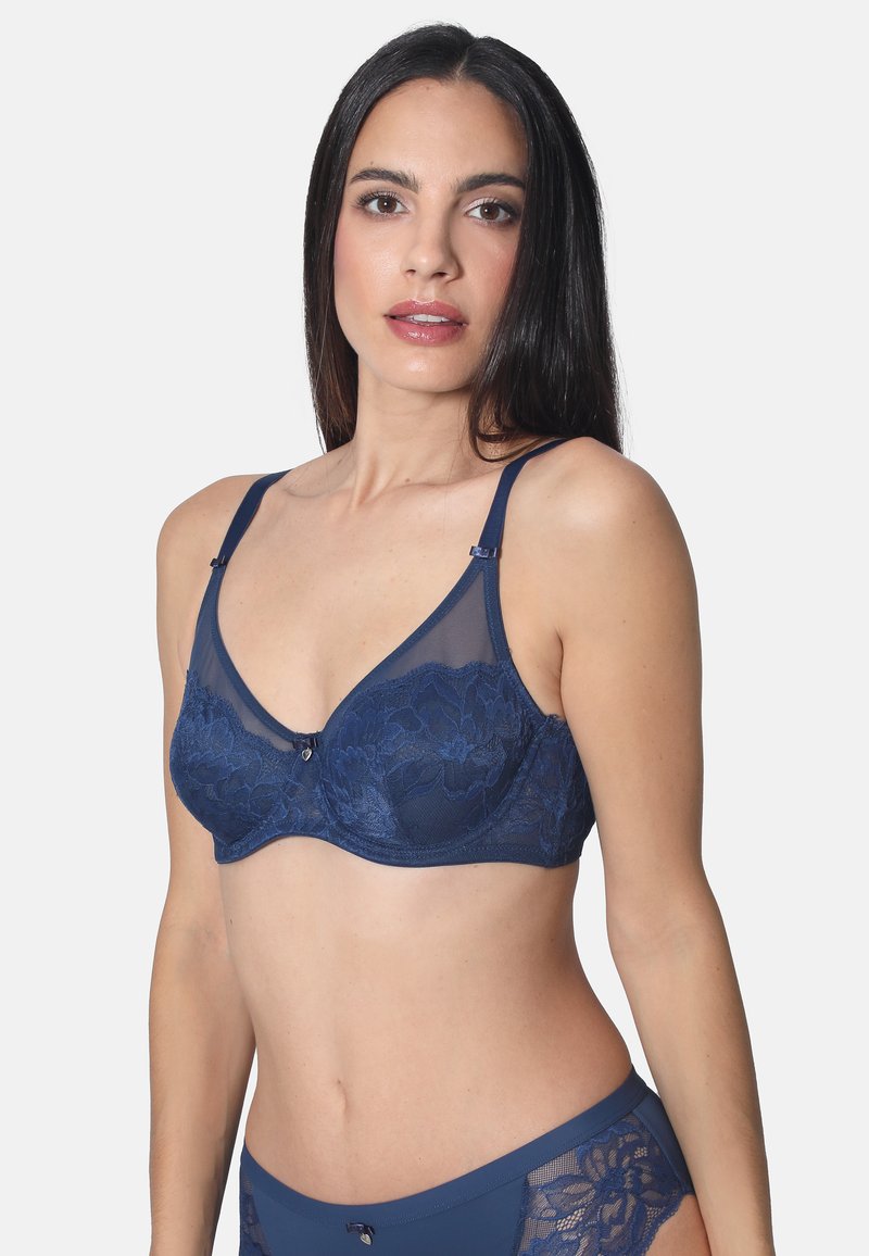 Marineblauer Spitzen-BH mit transparenten Mesh-Einsätzen, Bügelunterstützung, verstellbaren Trägern und einer kleinen dekorativen Schleife in der Mitte vorne.