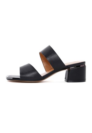 Mule noire à bout ouvert avec deux larges brides et un talon bloc sur fond blanc.