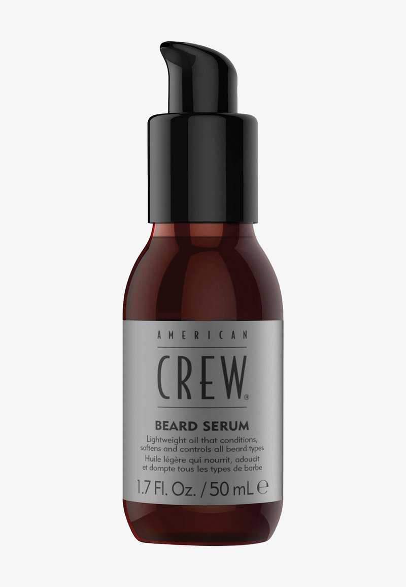Flacon marron de sérum pour barbe American Crew avec pompe noire et étiquette grise indiquant le nom du produit et les détails d'utilisation.