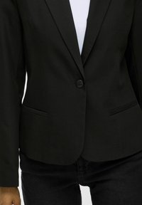 Černý blazer s jednobotonovým zapínáním, klopovými límečky a bočními kapsami. Ušitý design a hladký materiál s matným povrchem.