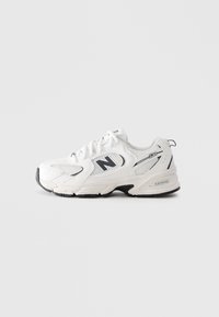 Sneaker New Balance 530 blanc avec accents noirs, panneaux en maille, lacets et semelle rembourrée sur un fond gris clair unicolore.