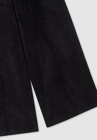 Tessuto in suede nero con una morbida texture, caratterizzato da un design liscio e dritto. Il materiale ha una leggera lucentezza e un aspetto raffinato.