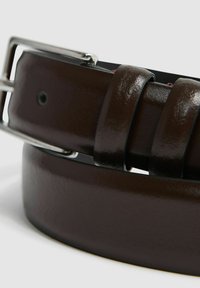Cinturón de cuero marrón con un acabado brillante, hebilla de metal plateado y detalles texturizados. El diseño incluye una forma y un estilo clásicos.
