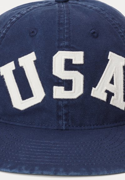 Marinblå baseballkeps med vita broderade "USA"-bokstäver på framsidan, tillverkad av slitstarkt tyg med en strukturerad form och böjd skärm.