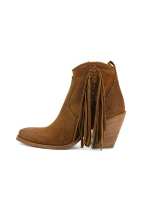 Stivaletto in pelle scamosciata marrone con tacco a blocco in legno impilato e lunghe frange intrecciate sul lato.
