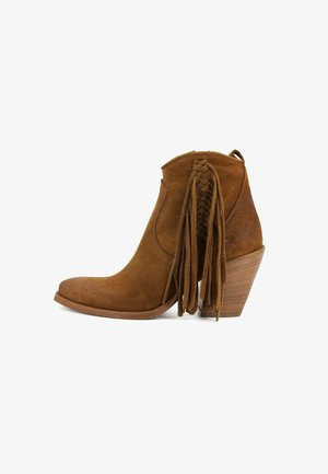Stivaletto in pelle scamosciata marrone con tacco a blocco in legno impilato e lunghe frange intrecciate sul lato.