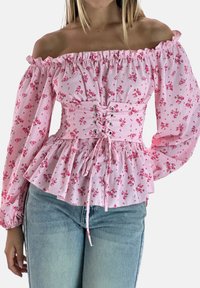 Rosa geblümte Carmenbluse mit Puffärmeln, gerafftem Rüschensaum und Schnürdetail vorne, aus leichtem Stoff gefertigt.