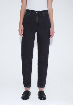 Black denim jeans with a high waist, slim fit, five-pocket design, visible stitching, and a button closure. Smooth texture and tapered leg.