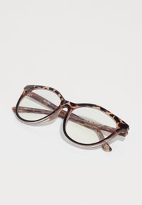 Gafas de gran tamaño con patrón de La Habana y un marco translúcido con lentes claros, que presentan una línea de cejas definida y un logo en la patilla.