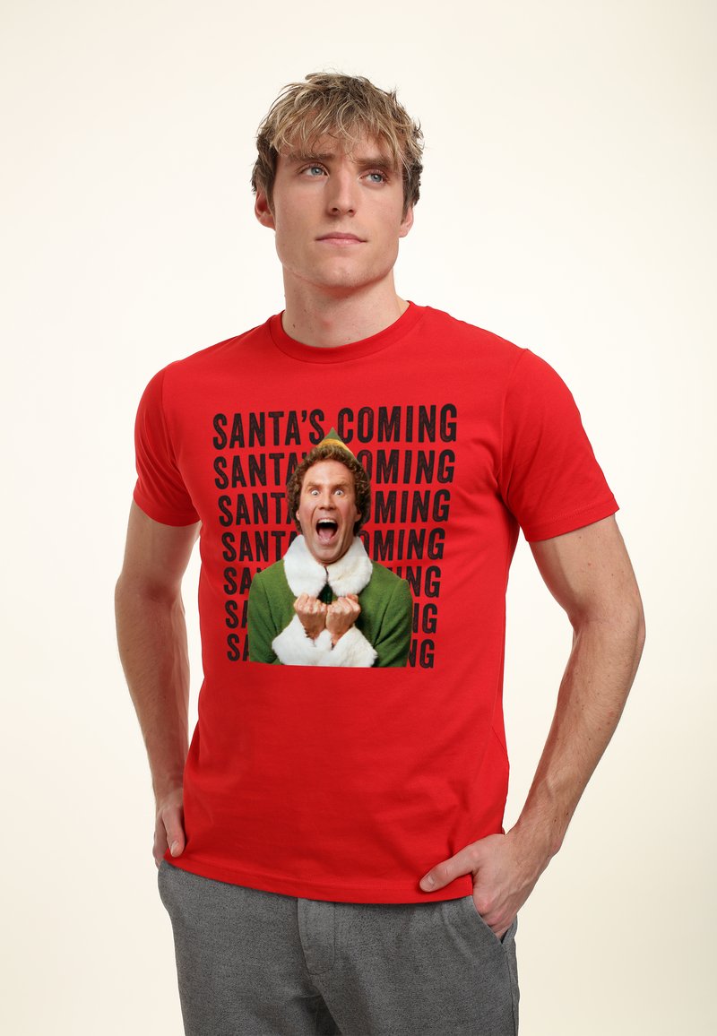 Červené bavlněné tričko s potiskem postavy v zelené barvě s bílým límcem a černým nápisem "SANTA'S COMING".