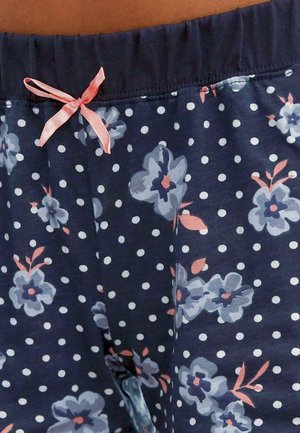 Navyblaue Schlafshorts mit weißen Polka-Dots, florales Muster in Hellblau und Pink, elastischer Bund und einem Detail aus pinkem Satinband.