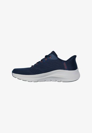 Zapatilla deportiva azul marino con suela blanca, parte superior perforada y ojales para los cordones en rojo, mostrada en perfil lateral sobre fondo blanco.