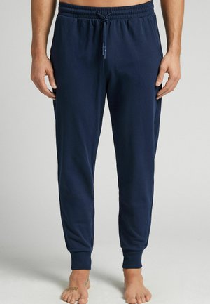 Marineblauwe joggingsbroek gemaakt van zachte katoen. Voorzien van een elastische tailleband met trekkoord en taps toelopende boorden bij de enkels.