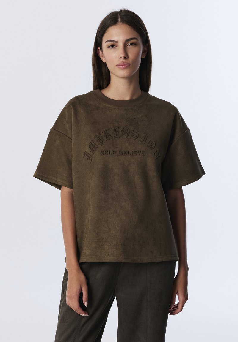Oversized bruine suède T-shirt met korte mouwen, met verhoogde tekst "IMPRESSIONS SELF BELIEVES" op de voorkant. Gladde textuur, relaxte pasvorm.