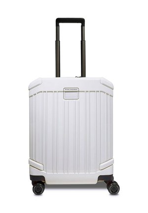 Valise rigide blanche avec rainures verticales, poignée noire et quatre roues ; comprend une plaque avec logo à l'avant.