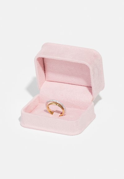 Anello d'oro e argento in una scatola di velluto rosa, caratterizzato da una fascia con una fila di piccole pietre trasparenti e una fascia interna liscia in oro.