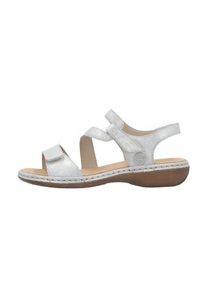 Silver metallic sandals with velcro straps, open toe design, cushioned insole, and a textured brown sole. Features a small logo on the side.