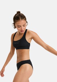 Black bikini set featuring a thick-strapped sports bra with a logo and matching low-rise bikini bottoms, made from smooth, stretchy material.