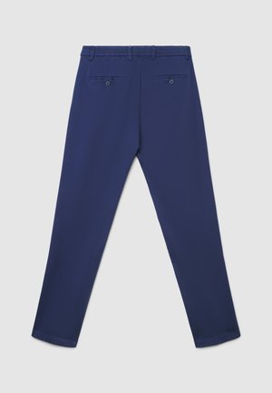 Pantaloni blu navy con tessuto liscio, vita elasticizzata e due tasche posteriori con chiusura a bottone. Design su misura con gamba affusolata.