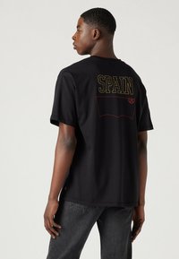 Levi's® FOOTBALL FAN TEE UNISEX - Apdrukāts T-krekls - black