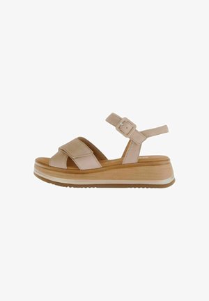 Sandales en plateforme beige avec des brides croisées en suède, une boucle réglable à la cheville et une semelle en bois léger avec des détails texturés.