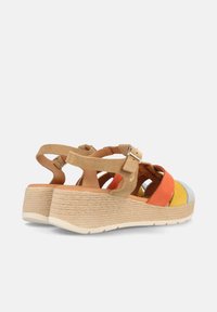 Sandalias de cuña coloridas con un upper de gamuza marrón, correas multicolores en naranja, amarillo y azul, y un tacón de plataforma con textura de cuerda tejida.