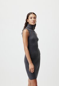Ribota adīta kleita tumši pelēkā krāsā, ar augstu turtleneck un bez piedurknēm, ar pielāgotu siluetu un mīkstu tekstūru.