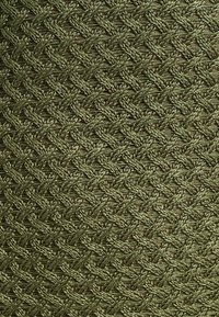 Green woven fabric with a textured herringbone pattern, featuring a coarse, rope-like appearance and varying shades of dark green.