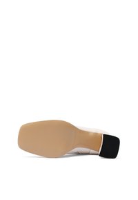 Scarpa con tacco dalla tomaia in pelle liscia rosa chiaro e tacco quadrato in gomma nera testurizzata. La parte inferiore presenta una suola beige con scanalature.