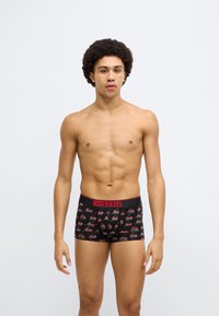 Fekete alsónemű piros derékpánttal, színes cseresznyemintával. Puha anyagból készült, testhezálló boxer stílusban tervezve.