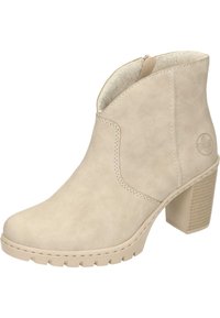 Botte de cheville beige en suède doux avec un talon carré texturé, un bout arrondi et un détail de couture visible sur le côté.