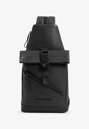 Sac à dos en cuir noir doté d'un dos rembourré, de bretelles réglables, d'une poche zippée à l'avant et d'une fermeture supérieure roulée avec une boucle.