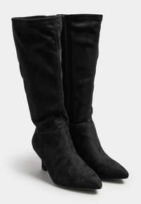 Botas negras hasta la rodilla de material de ante suave, con puntera afilada, tacón bajo y cremallera de longitud completa para un fácil uso.