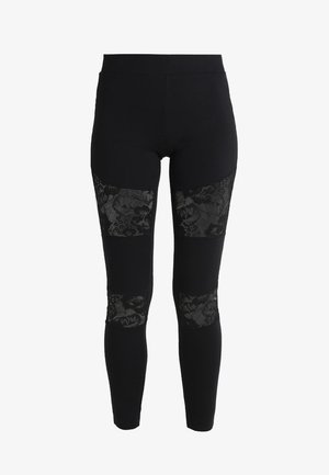 Czarne legginsy z misternymi czarnymi koronkowymi panelami na wysokości kolan, z gładkiego, elastycznego materiału i dopasowanym krojem.
