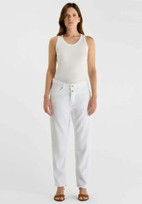 Witte high-waisted jeans met een losse pasvorm, voorzien van twee zakken aan de voorkant en goudkleurige knopen, gecombineerd met een wit tanktop en bruine sandalen.